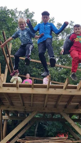 3 boys jumping off a wooden platform