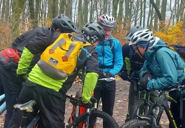 A group of cyclists in a woodland reading a map